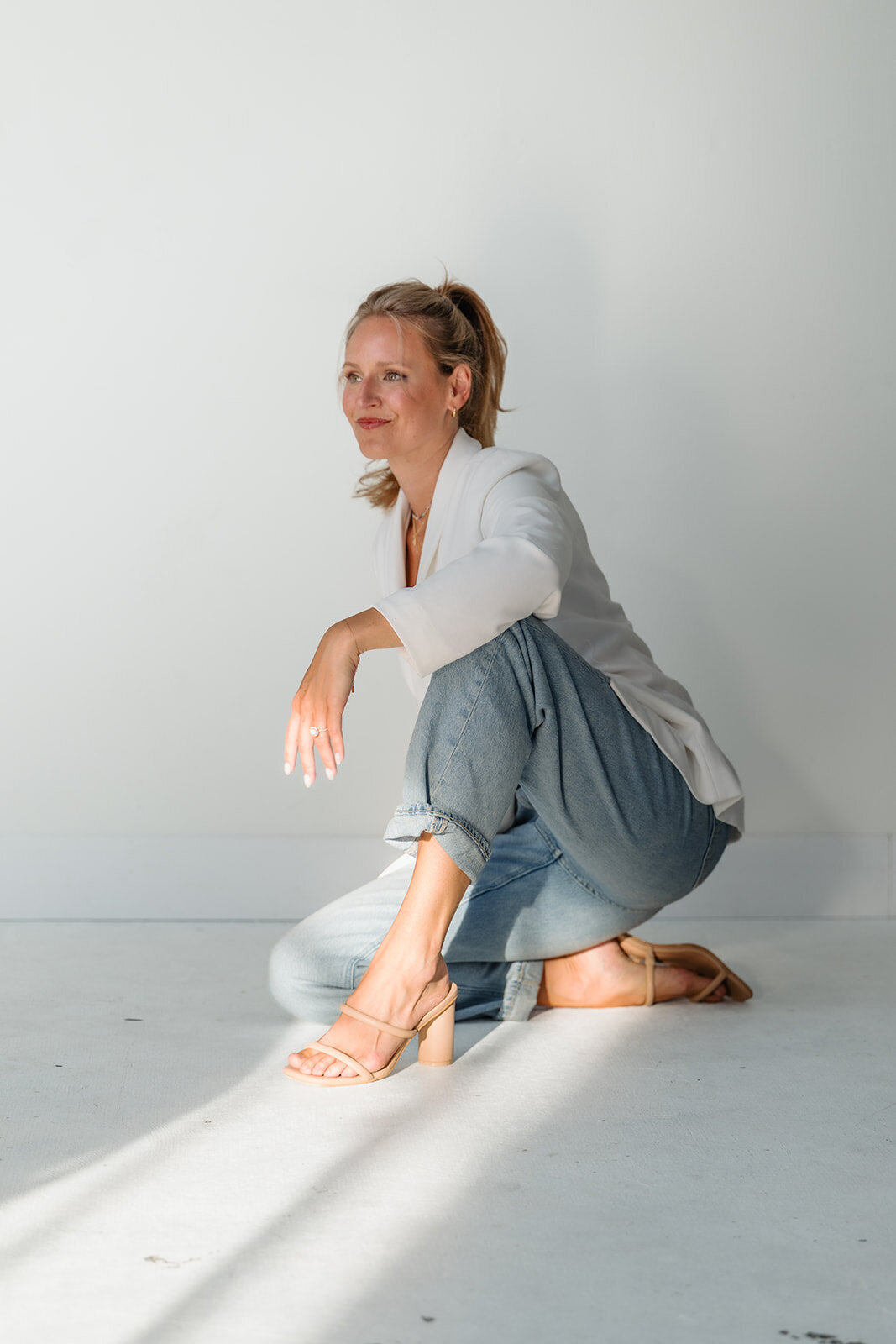Alex seated in a white studio